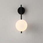 Applique murale moderne et minimaliste avec une tige en métal noir et un globe en verre dépoli, sur fond gris