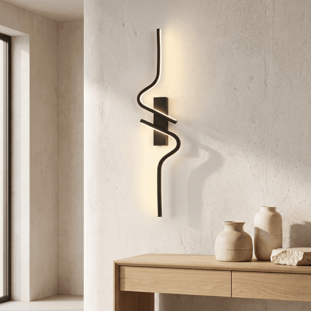 Applique murale noire en spirale diffusant une lumière LED chaude sur un mur texturé