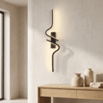 Applique murale noire en spirale diffusant une lumière LED chaude sur un mur texturé