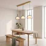 Suspension à trois abat-jour au-dessus d'une longue table en bois avec une plante