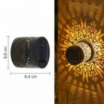 Applique solaire à motif mandala ajouré projetant un décor floral sur une porte en bois