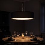 Suspension ronde en tissu noir allumée la nuit au-dessus d'une table