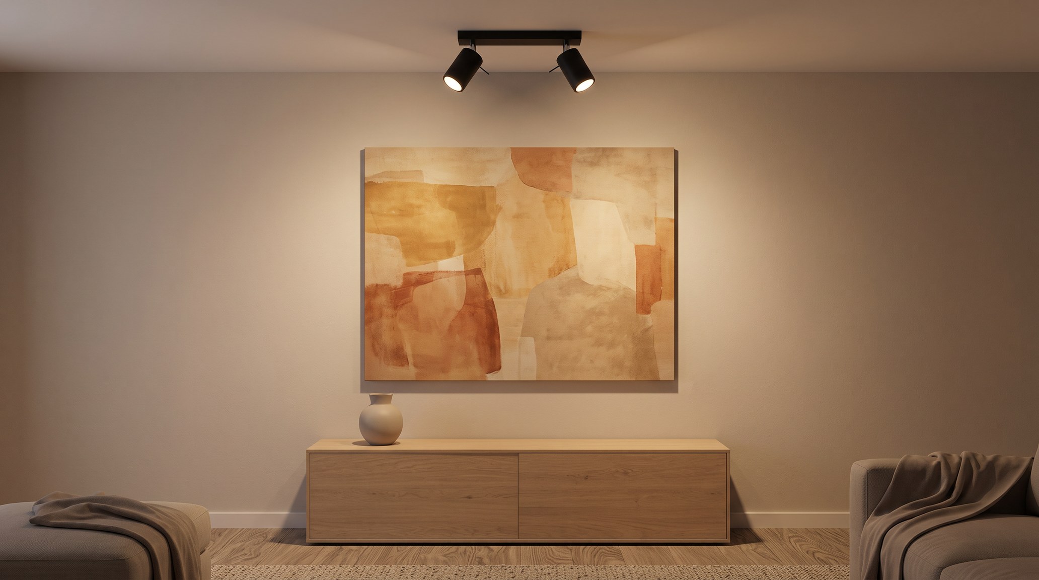 Grande toile abstraite aux tons ocre et terracotta accrochée au-dessus d'un buffet en chêne, éclairée le soir par une barre de deux spots noirs orientables fixée au plafond