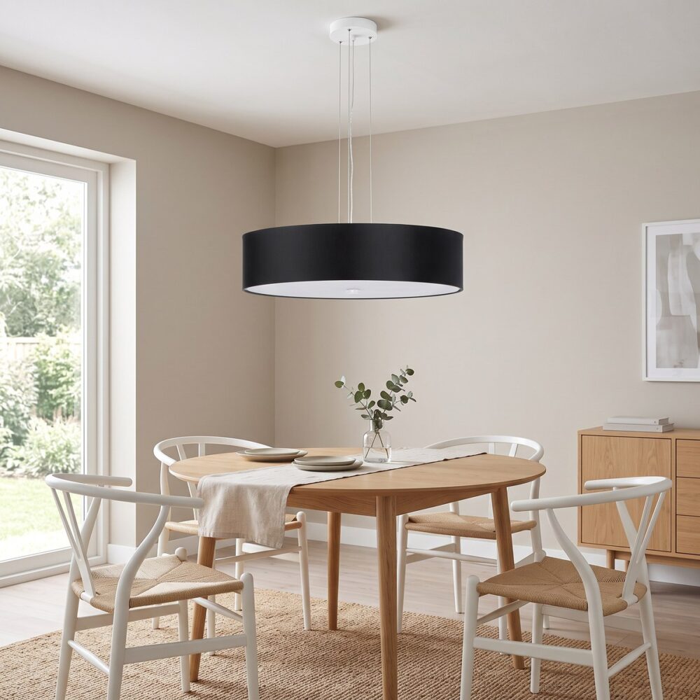 Suspension ronde en tissu noir au-dessus d'une table ronde en chêne