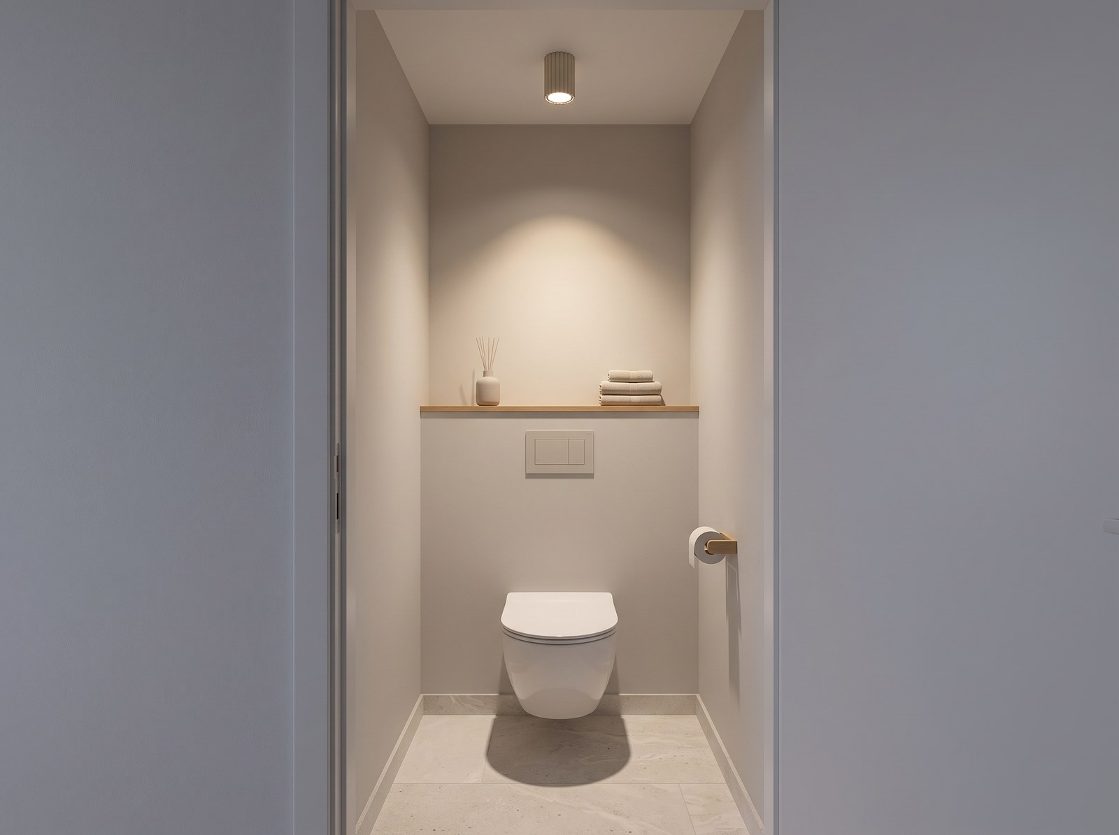 Petit plafonnier cylindrique beige en aluminium rainuré allumé au plafond de toilettes étroites aux murs clairs, dessinant un cône de lumière chaude sur le mur au-dessus de la cuvette